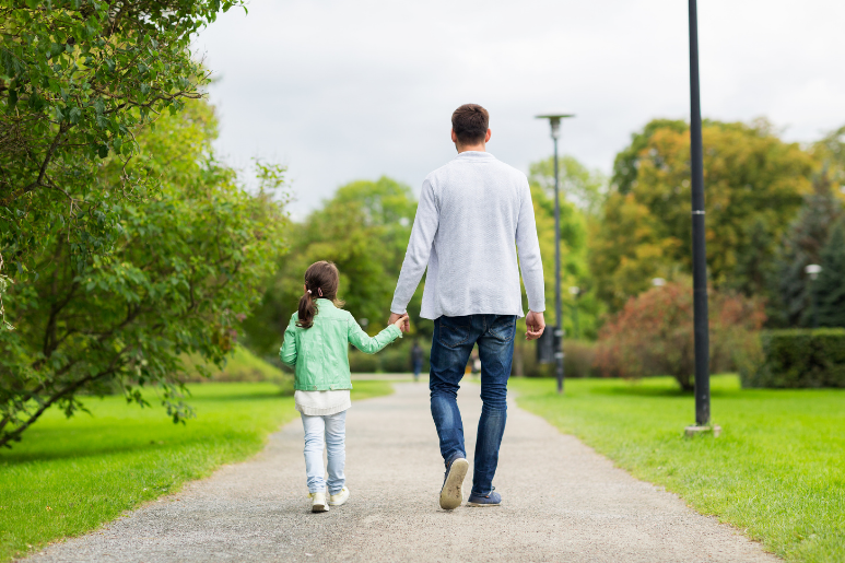 father walking with child holding hands